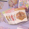 Carnet à spirales contenant 20 scènes de stickers isométrique 3D à composer soi-même sur le thème des boutiques kawaii et mignonnes. Activité créative pour adulte pour gérer le stress.