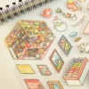 Carnet à spirales contenant 20 scènes de stickers isométrique 3D à composer soi-même sur le thème des boutiques kawaii et mignonnes. Activité créative pour adulte pour gérer le stress.