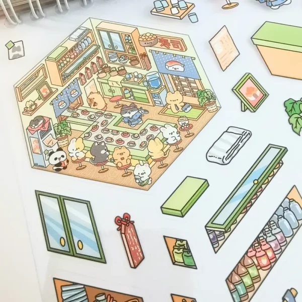 Carnet à spirales contenant 20 scènes de stickers isométrique 3D à composer soi-même sur le thème des boutiques kawaii et mignonnes. Activité créative pour adulte pour gérer le stress.