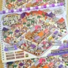 Carnet à spirales contenant 7 scènes de stickers isométrique 3D à composer soi-même sur le thème de la ville. Activité créative pour adulte pour gérer le stress.